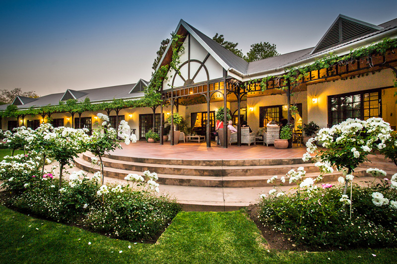 The warmly lit Hlangana Lodge entrance and flower gardens